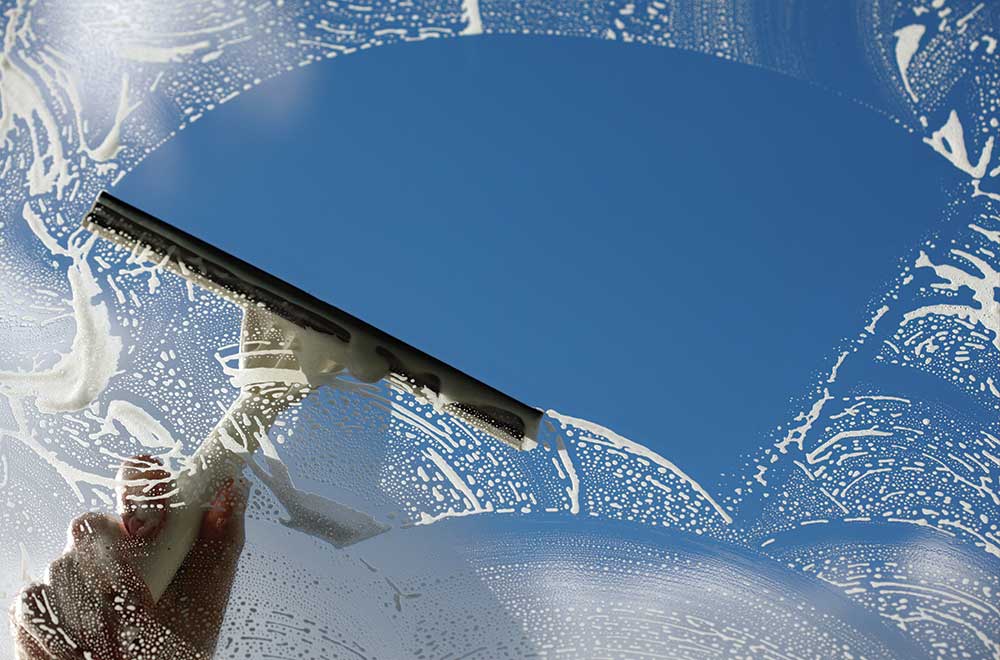 close up window squeegee cleaning window